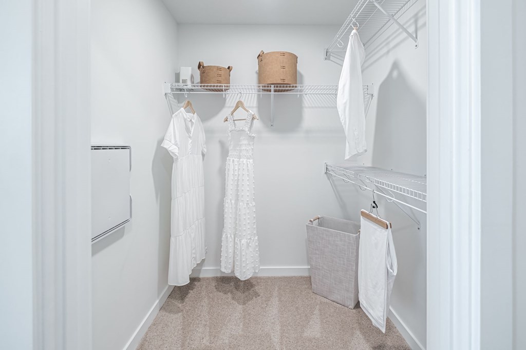 A spacious walk-in closet with built in shelves