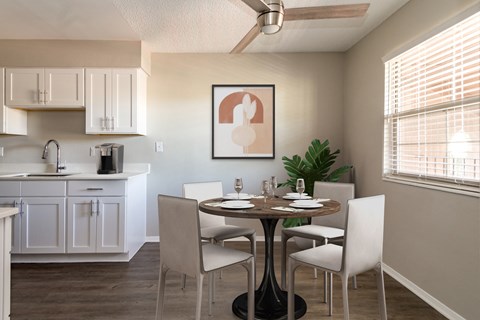 Renovated kitchen with white cabinetry, laminate countertop, and wood-style plank flooring | Acacia Gardens