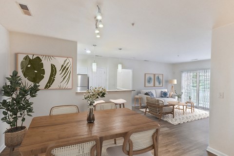 a living room and dining room with a wooden table and chairs