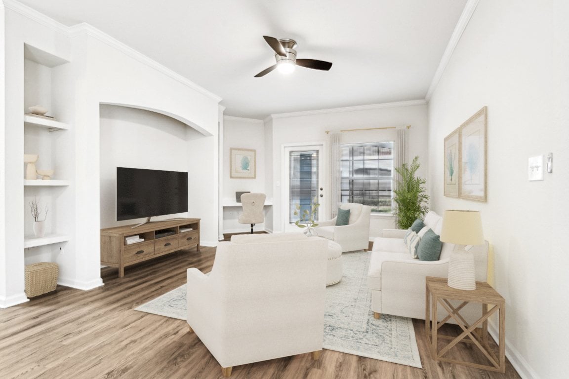 A living room with a white couch and a television.