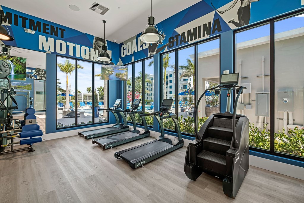A gym with treadmills and a sign that says