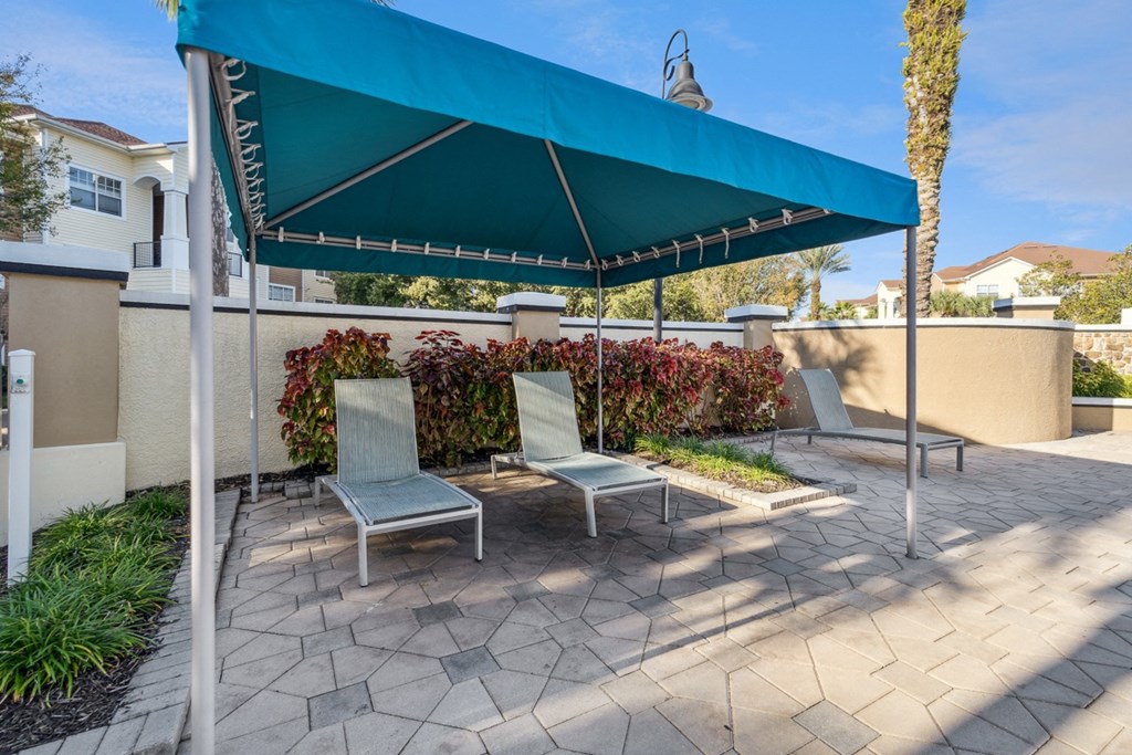 a patio with two lounge chairs under a canopy at Grandeville on Saxon, Orange City, 32763