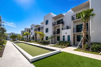 A white building with a green lawn in front.