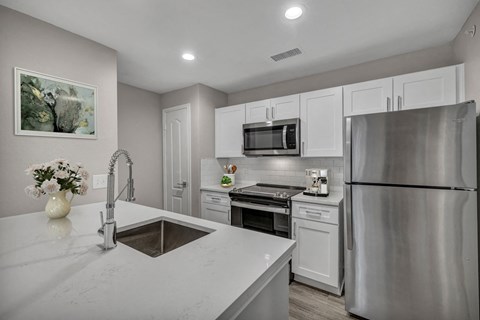 a kitchen with white cabinets and stainless steel appliances at River Stone Ranch, Austin