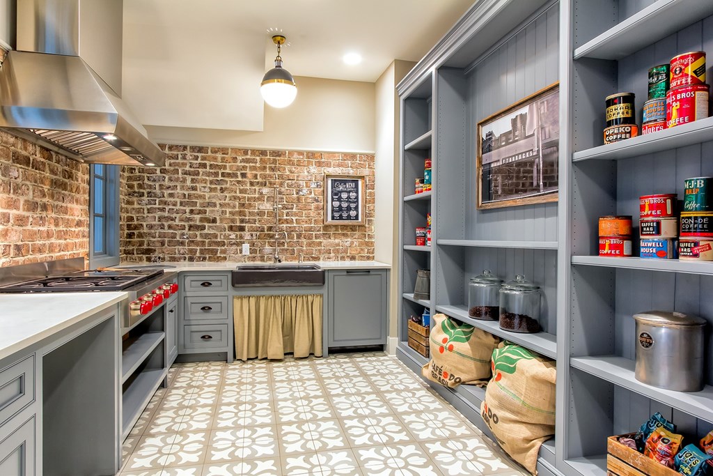 A kitchen with a brick wall and a tile floor at Wharf 7 Apartments, South Carolina