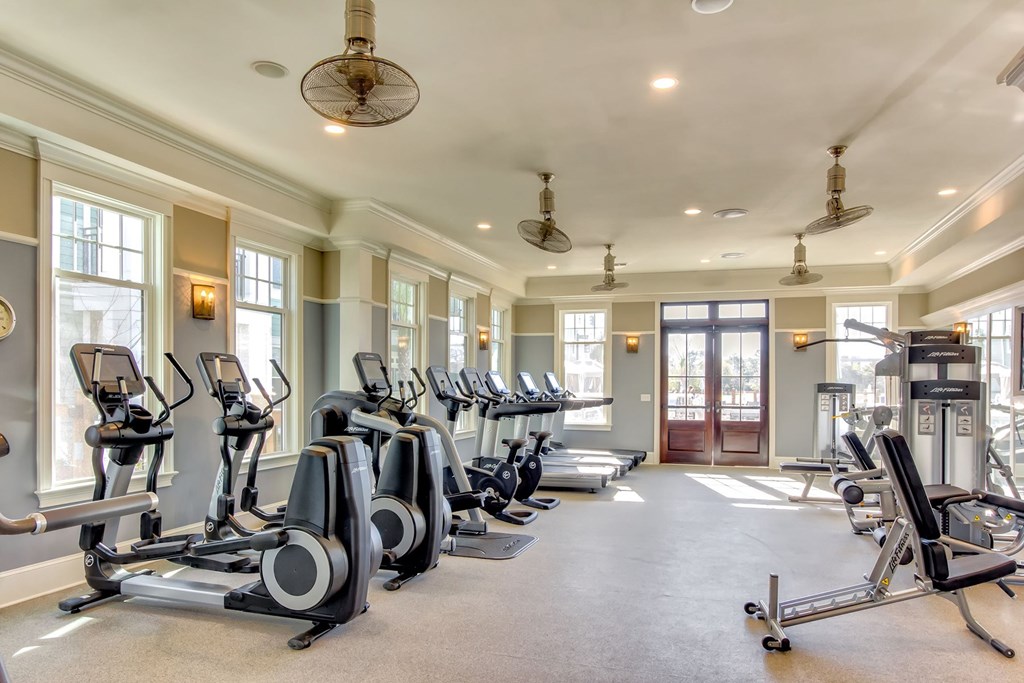 A spacious gym with treadmills, elliptical machines, and a rowing machine at Wharf 7 Apartments, Charleston