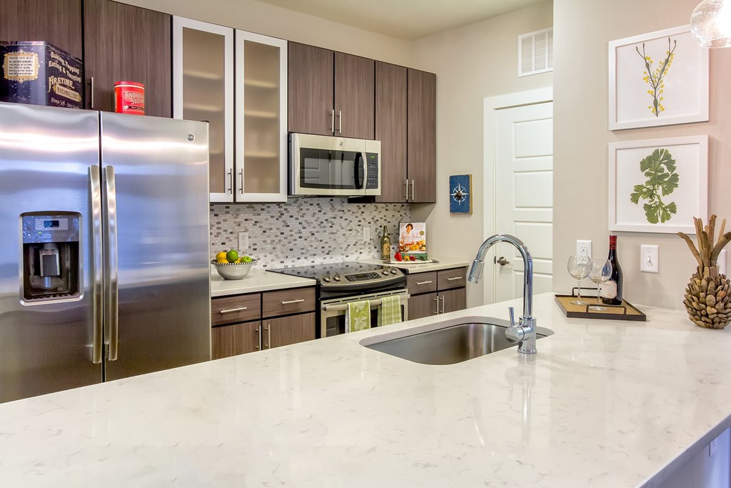 A kitchen with a marble counter top and stainless steel appliances at Wharf 7 Apartments, Charleston, South Carolina