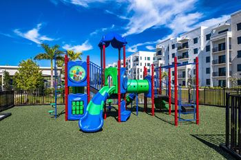A playground with a blue slide and red and green play structures.