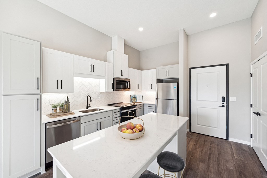a kitchen with white cabinets and stainless steel appliances and a white counter topat SoRoc On Maine, Rochester 