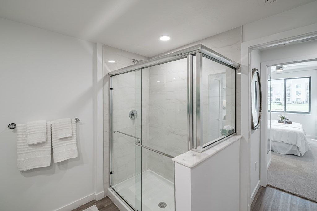 A white bathroom with a spacious glass shower