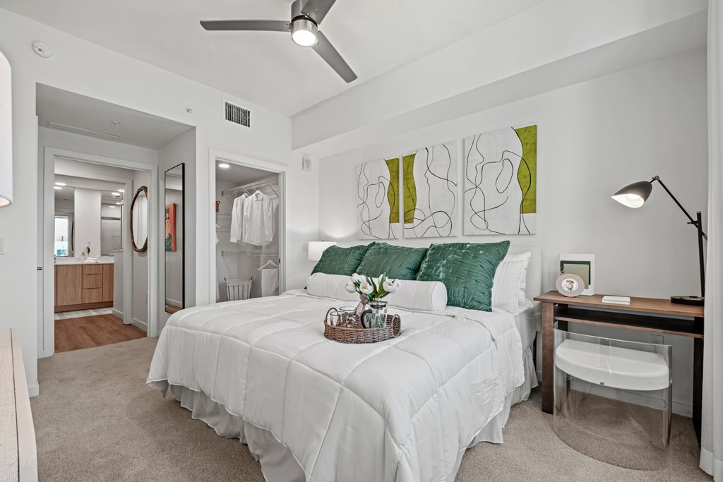 A generously sized bedroom with a connected bathroom and a walk-in closet