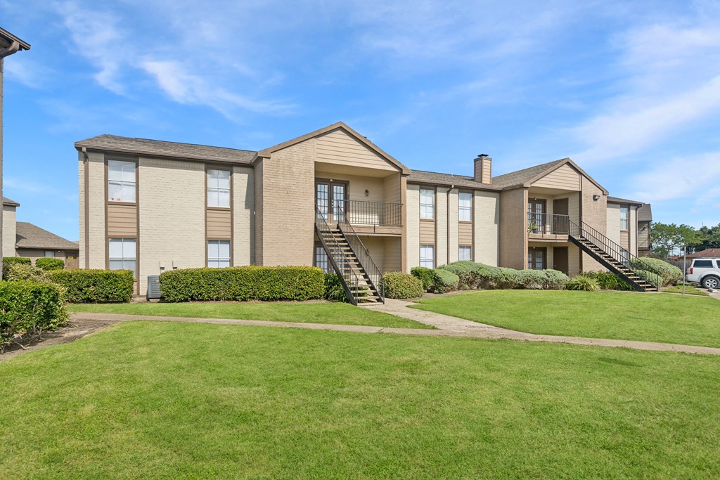 A large apartment complex with a green lawn in front.