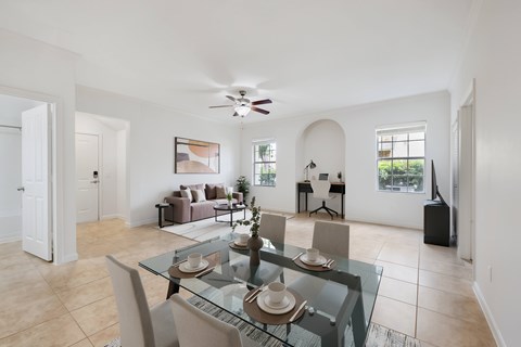 A dining room with a glass table and chairs.