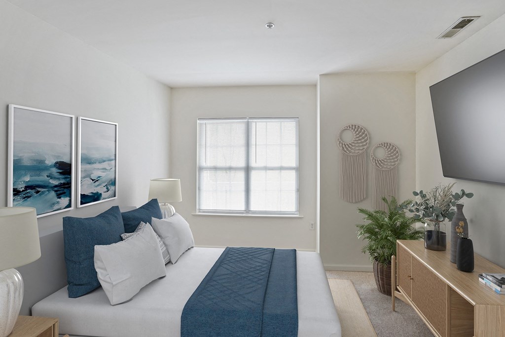 a bedroom with a large bed and a tv at Highlands at Faxon Woods, Quincy