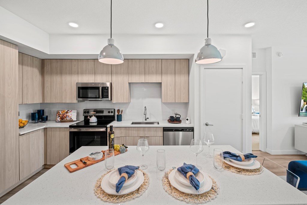 A modern kitchen with a white island and stainless steel appliances