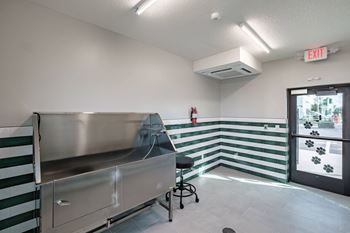 A room with a striped wall and a stainless steel table.