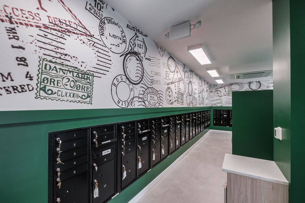 A long hallway with locker rooms and a wall with postage stamps on it.