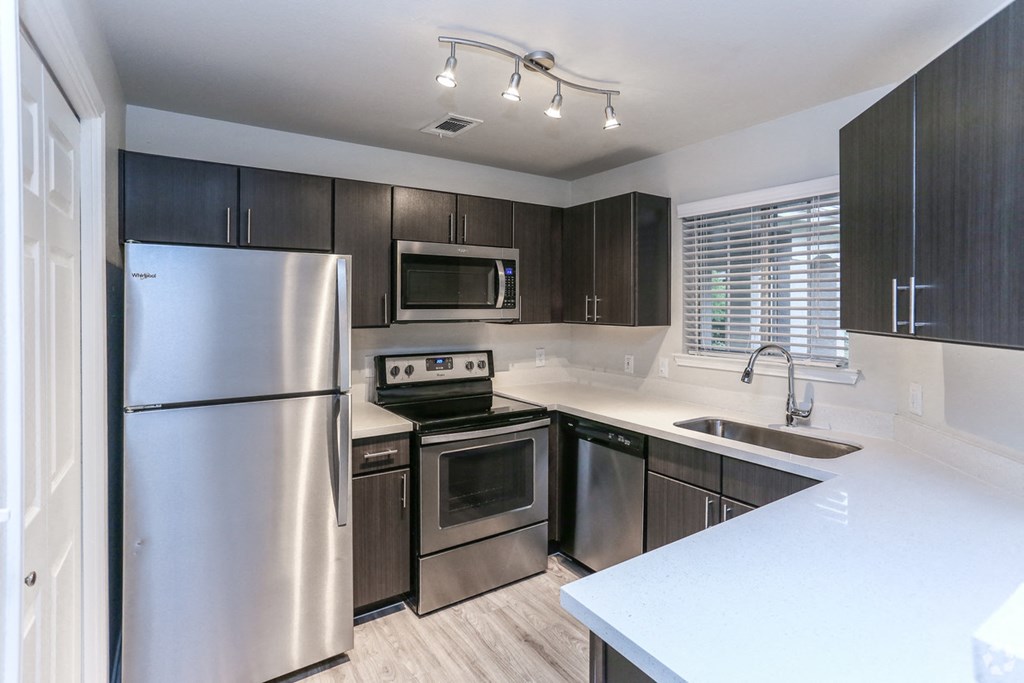 Renovated kitchen with dark cabinets, light counters at Northland at the Arboretum, Austin, Texas