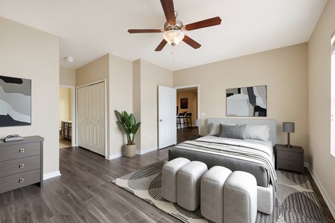 A bedroom with a large bed and a ceiling fan.