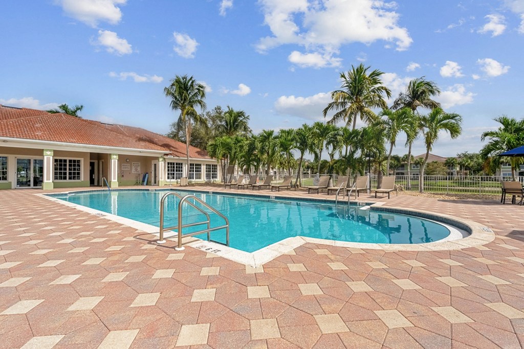 a swimming pool in front of palm trees at Bay Breeze Villas, Fort Myers, FL