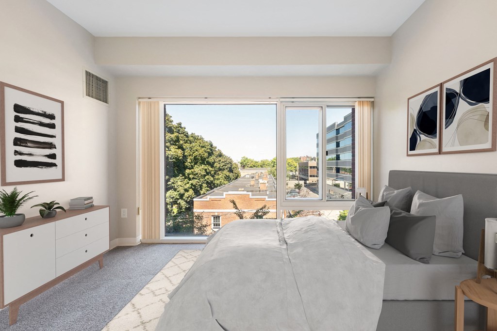 a bedroom with a bed and a large window at the Residences at Manchester Place in Manchester, New Hampshire