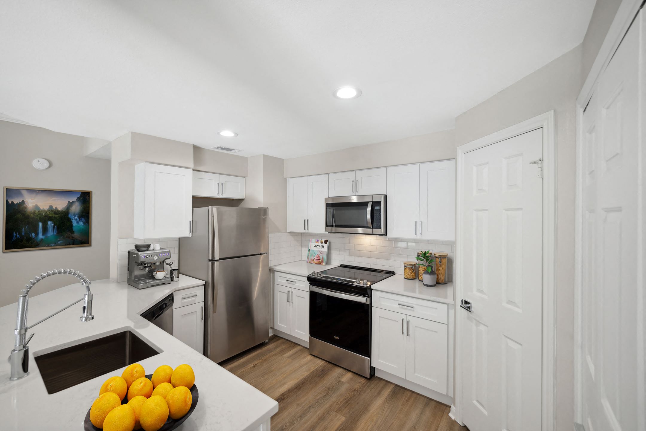 a kitchen with stainless steel appliances and white cabinets