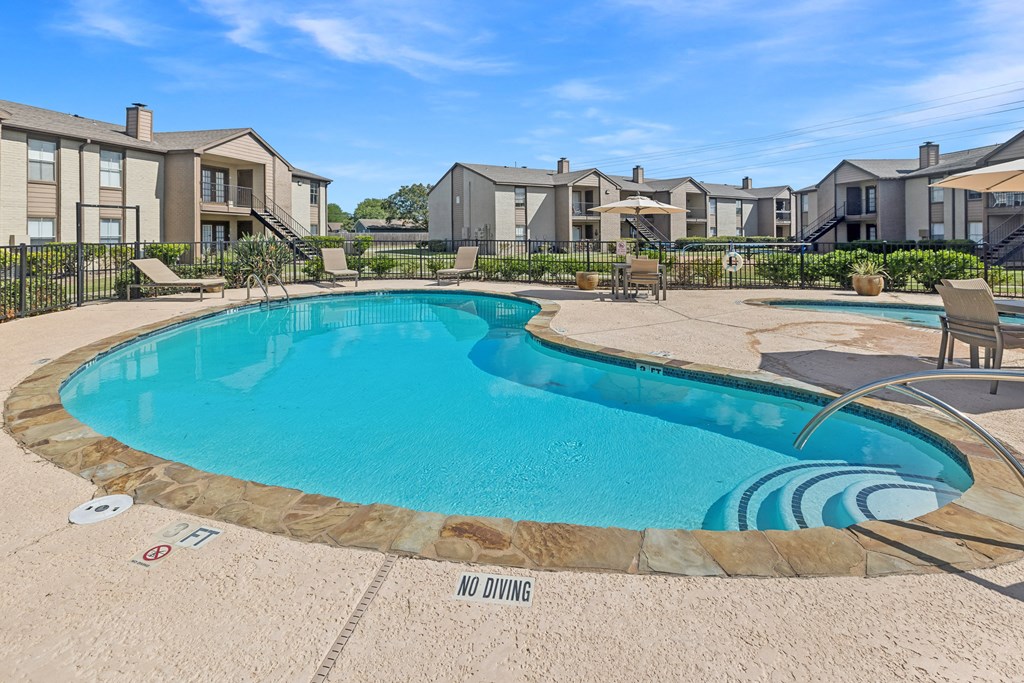 A swimming pool surrounded by a fence with the words