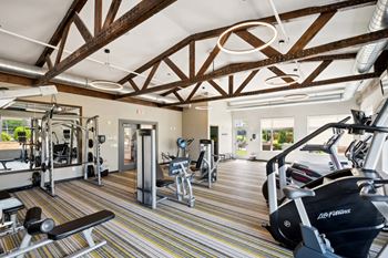 a fully equipped fitness center with cardio and weight equipment at SoRoc on Maine apartments in Rochester, MN