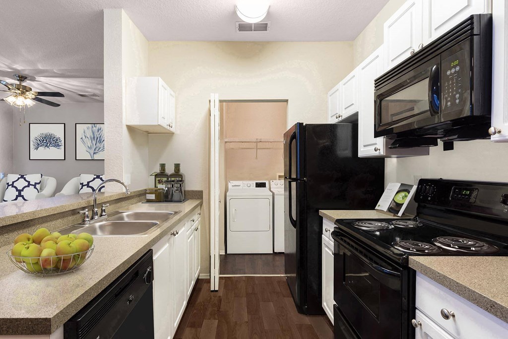 a kitchen with black appliances and white cabinets at Bella Vista on Park, Plant City Florida
