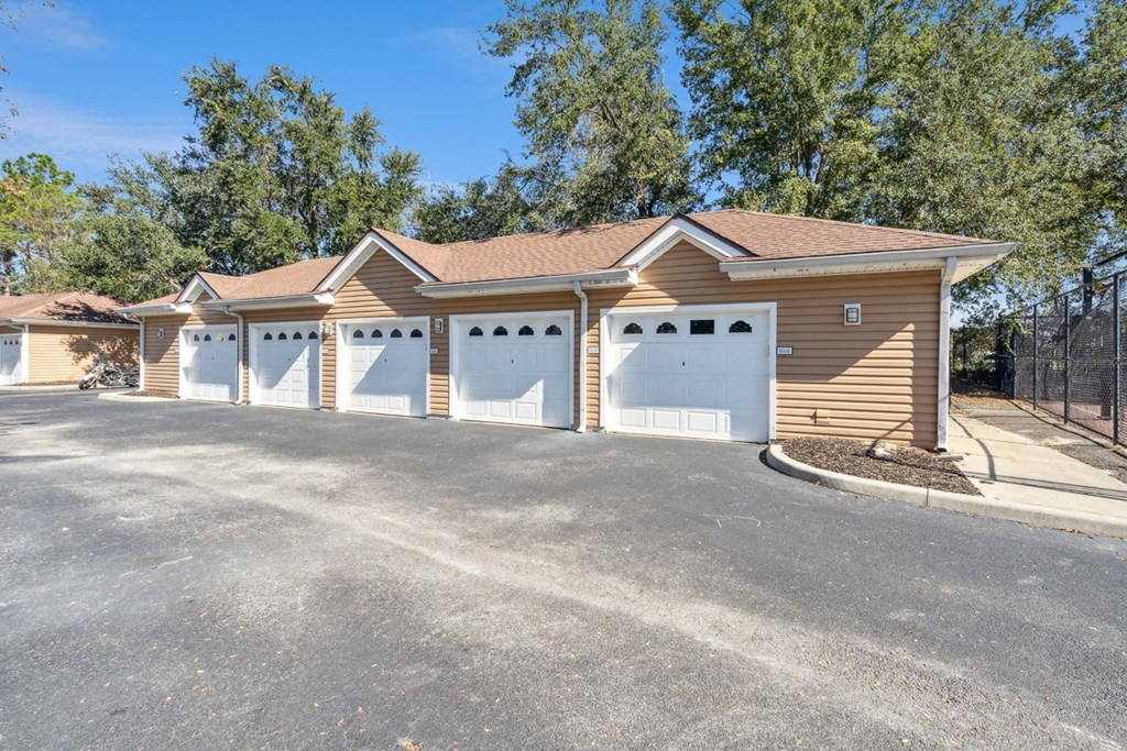 a parking lot with a row of garages in front of a building at Grandeville on Saxon, Orange City, FL