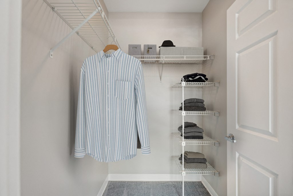 a walk in closet with a shirt hanging on a rack and shelf at the Residences at Manchester Place in Manchester, New Hampshire