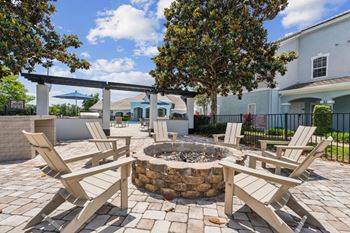 a backyard with a fire pit and chairs  at Ballantrae Apartments, Sanford