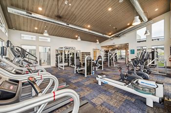 Fitness center with cardio equipment and weights in a building with wood ceilings