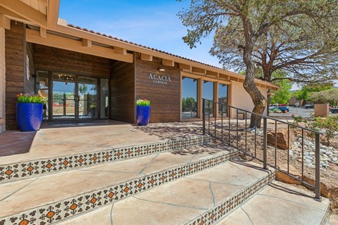 a building with stairs and a glass door with a tree in front of it at Acacia Gardens, Albuquerque, NM, 87111