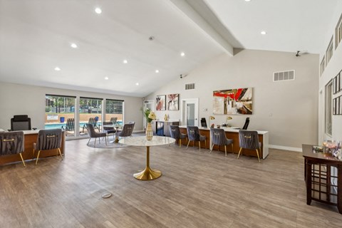 the gathering room with tables and chairs and a view of the pool at Acacia Gardens, Albuquerque, New Mexico