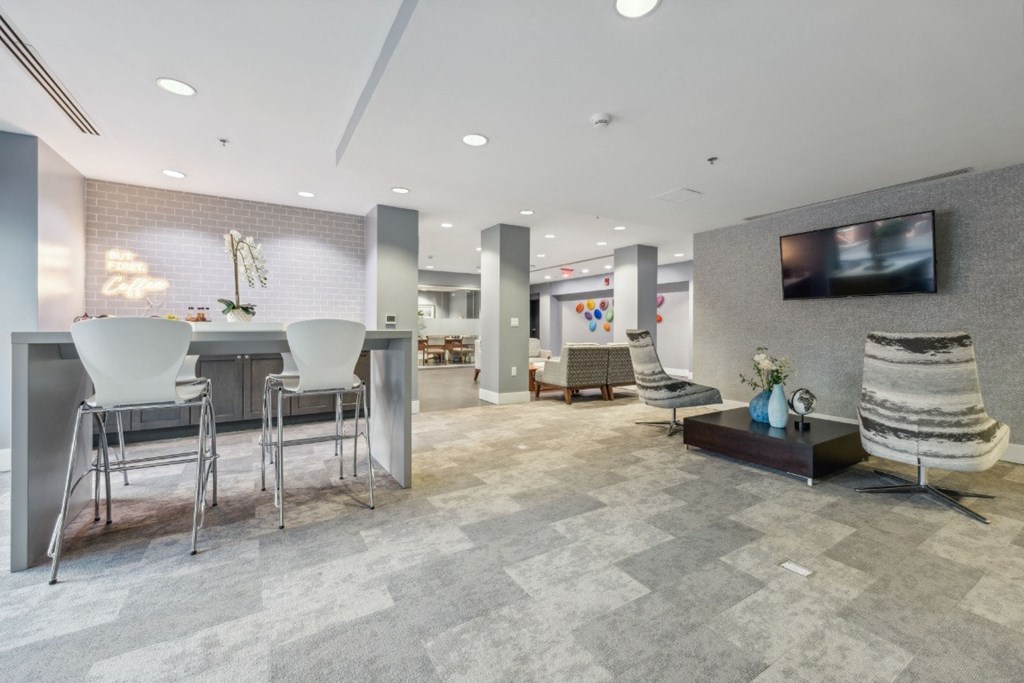 clubroom with a table, chairs, and a television at the Residences at Manchester Place in Manchester, New Hampshire