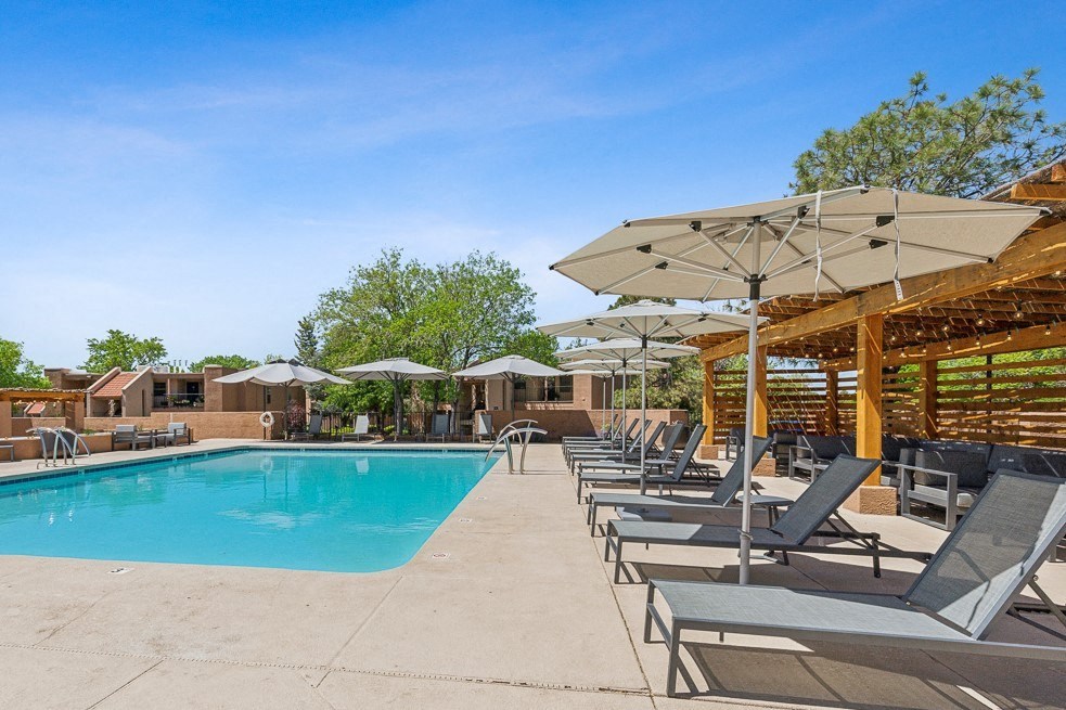 the resort style pool is surrounded by lounge chairs and umbrellas