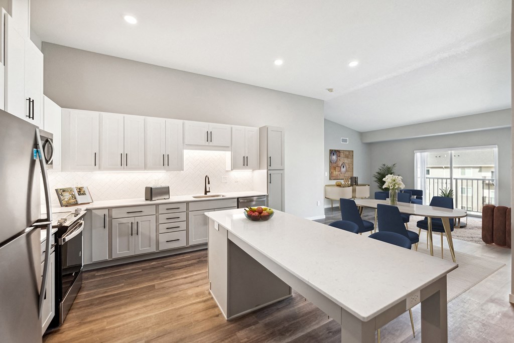 an open kitchen and dining room with white cabinets and a white tableat SoRoc On Maine, Minnesota, 55904