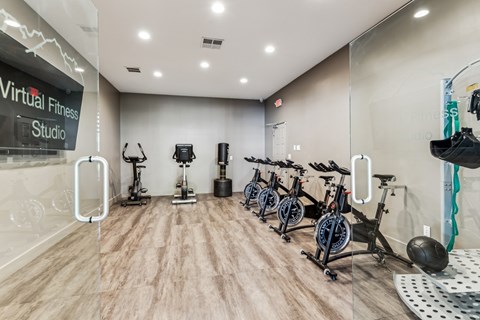 a fitness room with cardio bikes and weights on a wooden floor at Altezza High Desert, Albuquerque