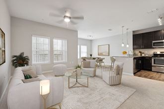 a living room with white couches and chairs and a kitchen with dark cabinets - Photo Gallery 4