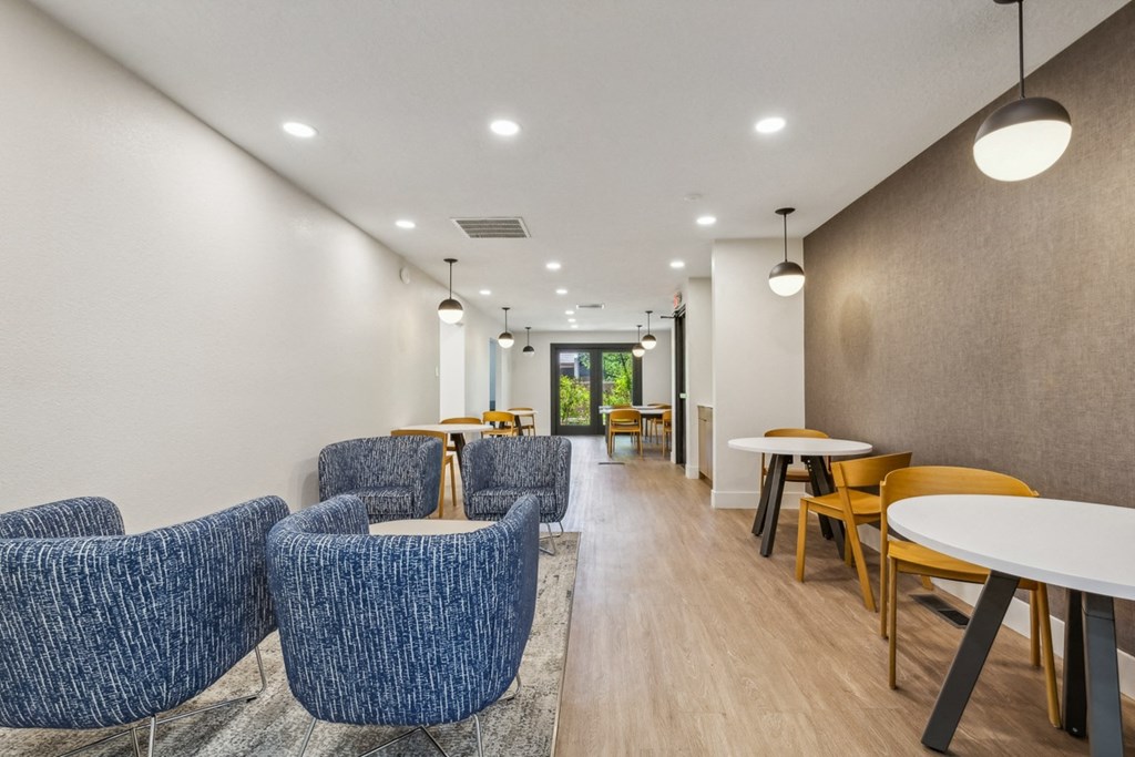 a long corridor with blue chairs and tables in a hospital lobby at Acacia Gardens, Albuquerque, NM, 87111