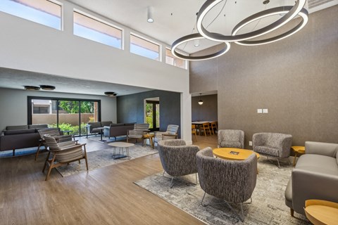 a large living room with chairs and tables and a large window at Acacia Gardens, Albuquerque, NM, 87111