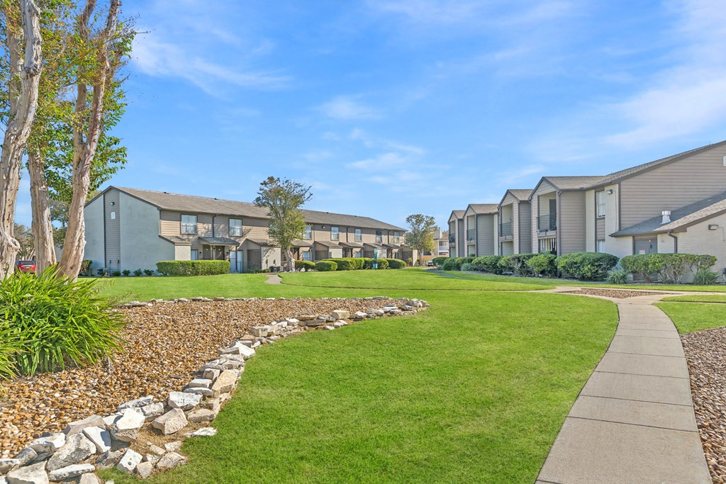 A row of houses with a stone pathway leading to them.