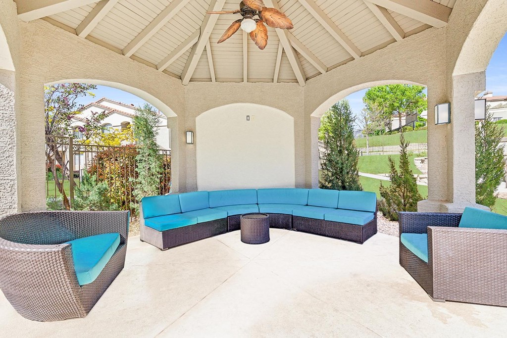 a covered patio with a blue couch and chairs