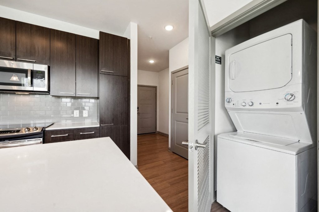 a kitchen with a washer and dryer and a door to a laundry room at Glenwood at Grant Park Apartments, Atlanta, GA