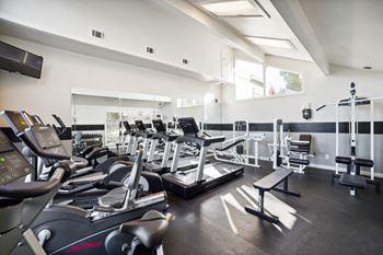 a gym with cardio equipment and weights on the floor at Great Hills, Austin, Texas