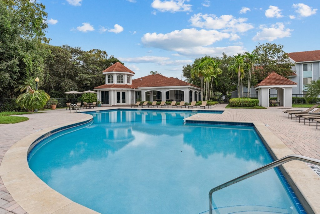 a large swimming pool with a clubhouse in the background at Cypress Shores, Coconut Creek, 33063