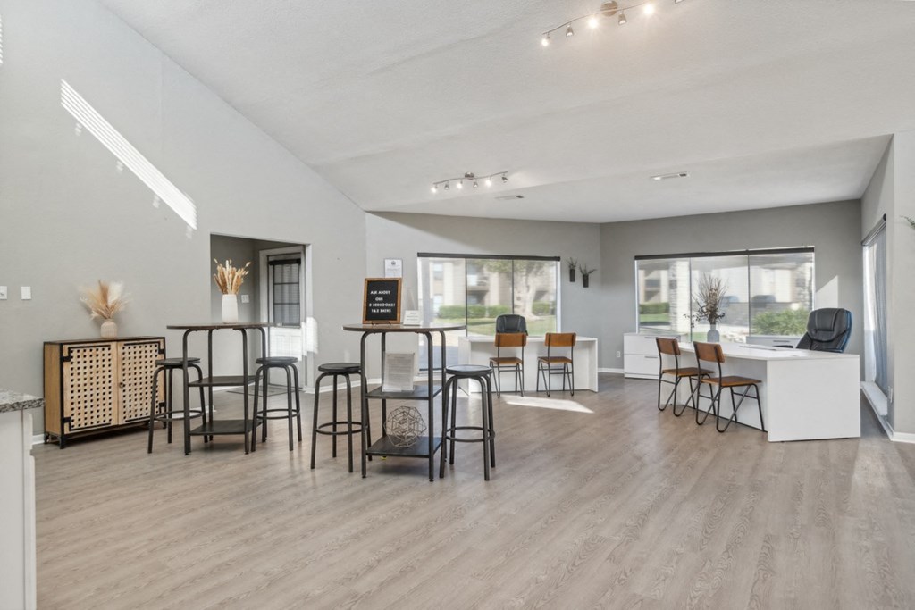 A modern living room with a variety of seating options and a large window.