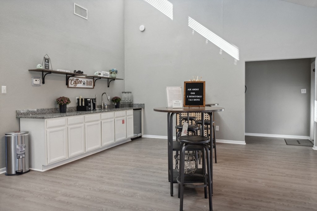 A bar area with a white counter and a black stool.