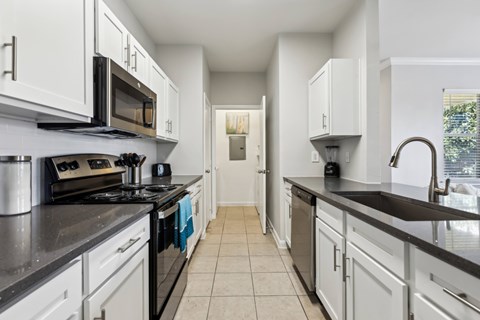 A Kitchen with Black Countertops at Flats on Chapel Apartments, Waco